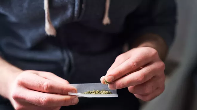 Fingers rolling a joint