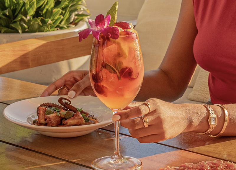 Image: a hand holding a drink