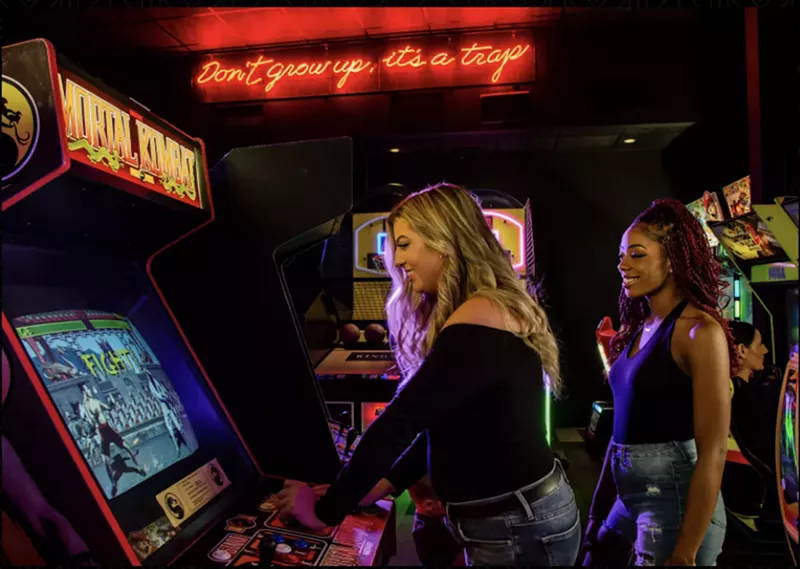 Image: Two women playing arcade games at Kings Dining & Entertainment