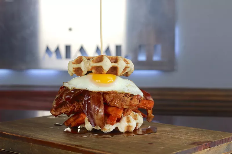 Image: 109 Burger's Wake Up, with applewood-smoked bacon, hash browns, charred balsamic onions, homemade "baby pink sauce," and a fried egg sandwiched between two fluffy waffles.