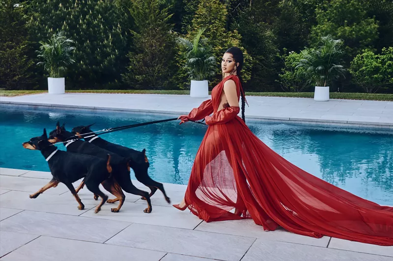Image: Cardi B in a red dress in front of a pool