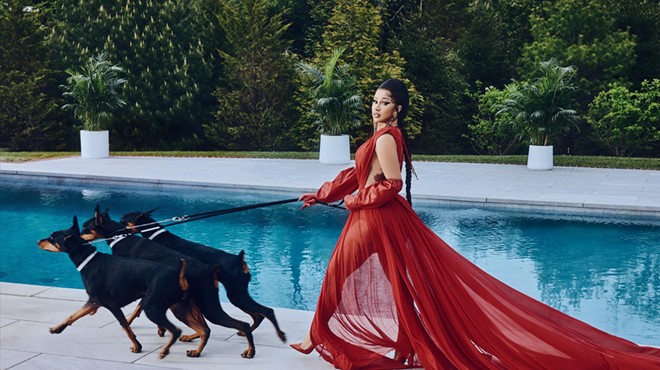 Cardi B in a red dress in front of a pool