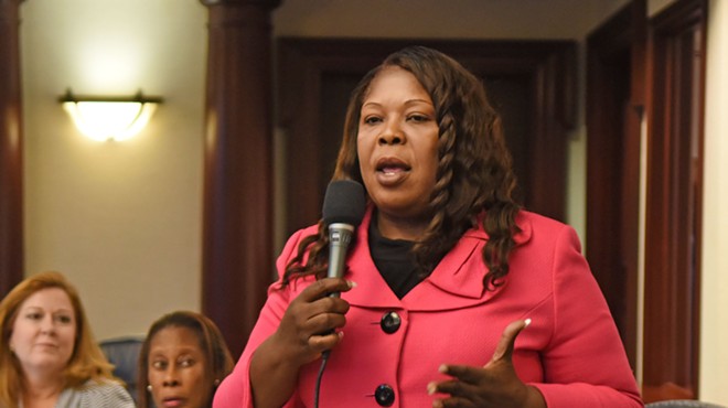 North Miami politician Daphne Campbell holds a microphone while speaking to an audience