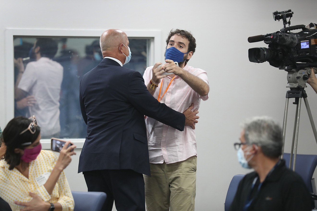 Thomas Kennedy is escorted away by security after interrupting Florida Gov. Ron DeSantis during a news conference.
