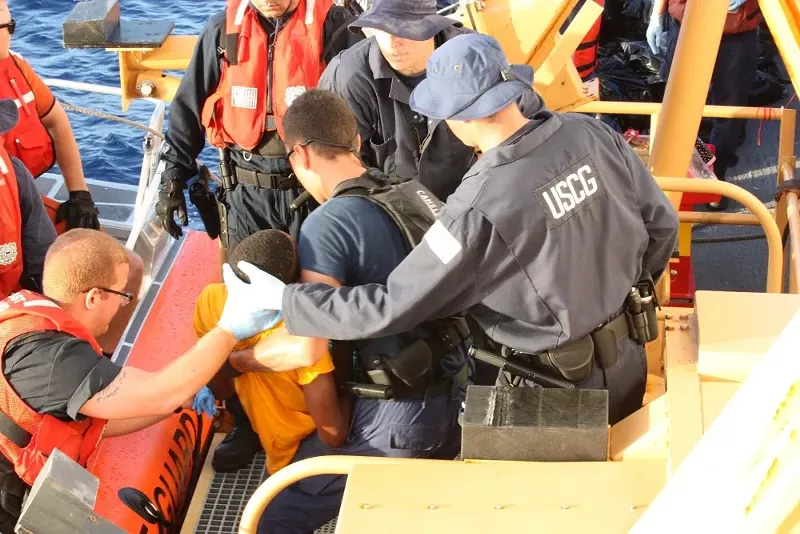 Image: The U.S. Coast Guard places a Haitian migrant on a cutter near Great Inagua, Bahamas, in March 2018.