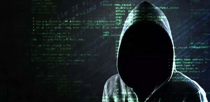 Image: a hooded character with code behind him