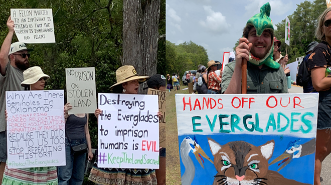 People hold signs protesting against Alligator Alcatraz in the Everglades