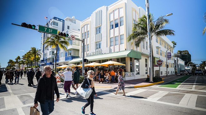 People walking along Ocean Drive in Miami Beach in front of art deco buildings