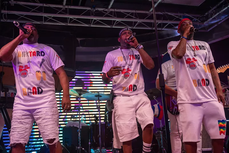 Image: A three-piece band singing on stage