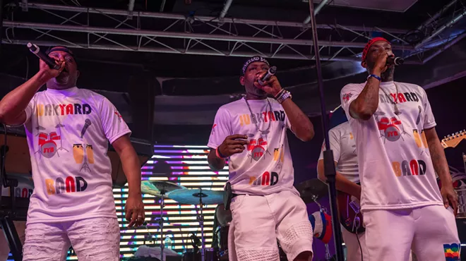 A three-piece band singing on stage