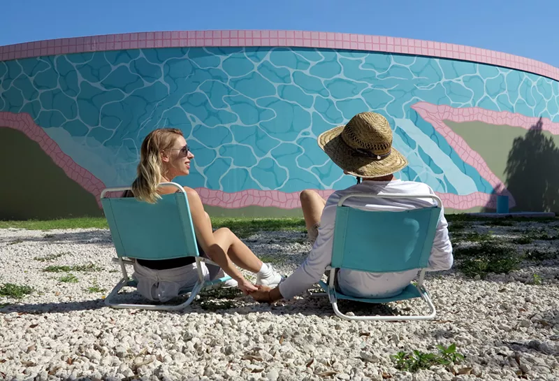 Image: The artist duo Nice'n Easy takes a break from painting the North Beach water tanks.