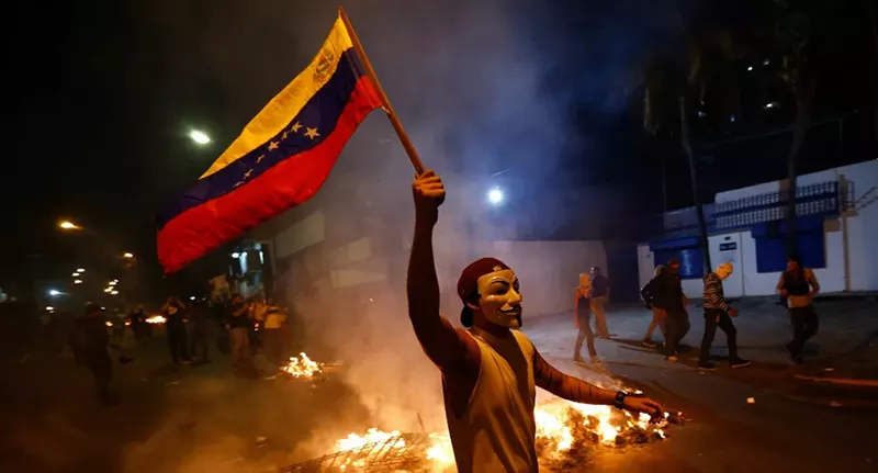 Image: A protester carries the Venezuelan flag during a Caracas protest last weekend. Hundreds of thousands marched yesterday.