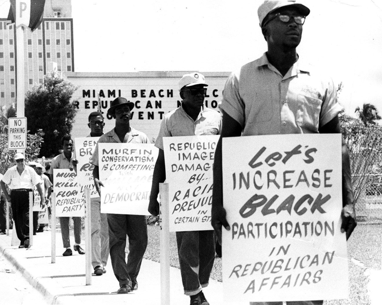 African-American men march outside the Miami Beach Convention Center.