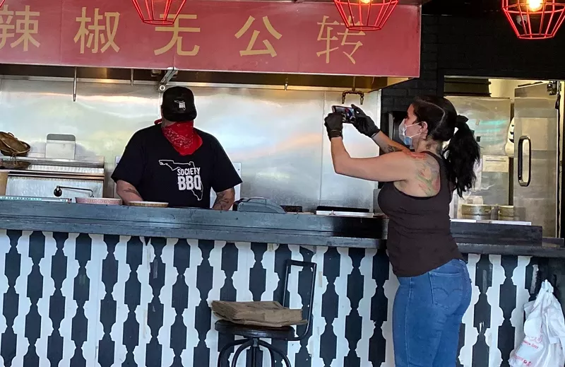 Image: Jenny Hales filming her husband Richard for a special "Takeout" edition of Diners, Drive-Ins and Dives.