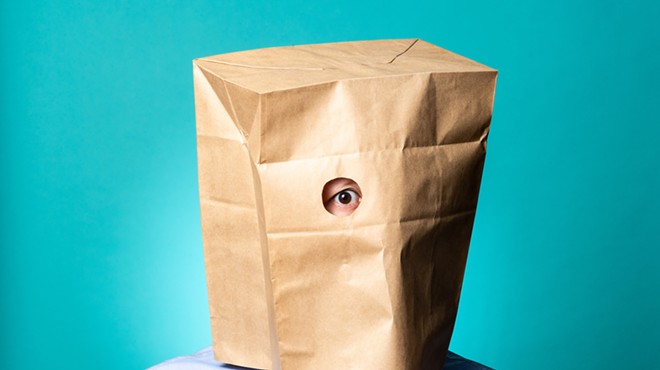 photo of a person with a brown paper bag over their head.