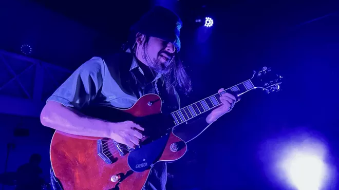 A guitarist playing a red Gretsch