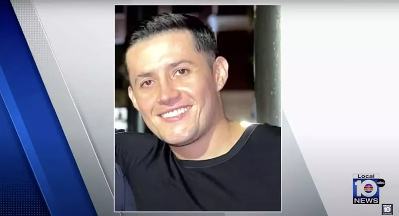 Image: A young man in a black t-shirt smiles.