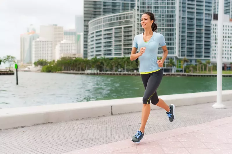 Image: Young woman jogging near water in Miami's Brickell neighborhood