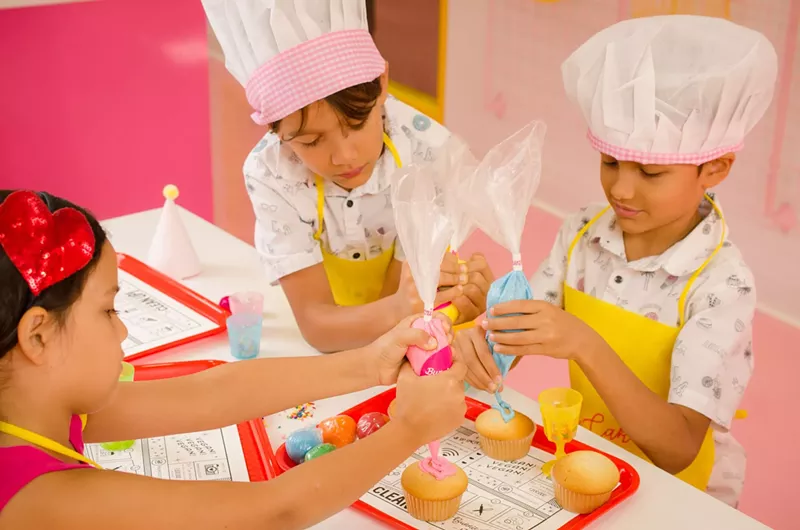 Image: Kids use buttercream to decorate their cupcakes.