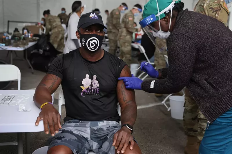 Image: A healthcare worker administers the Pfizer vaccine at the Miami Dade College North Campus site.