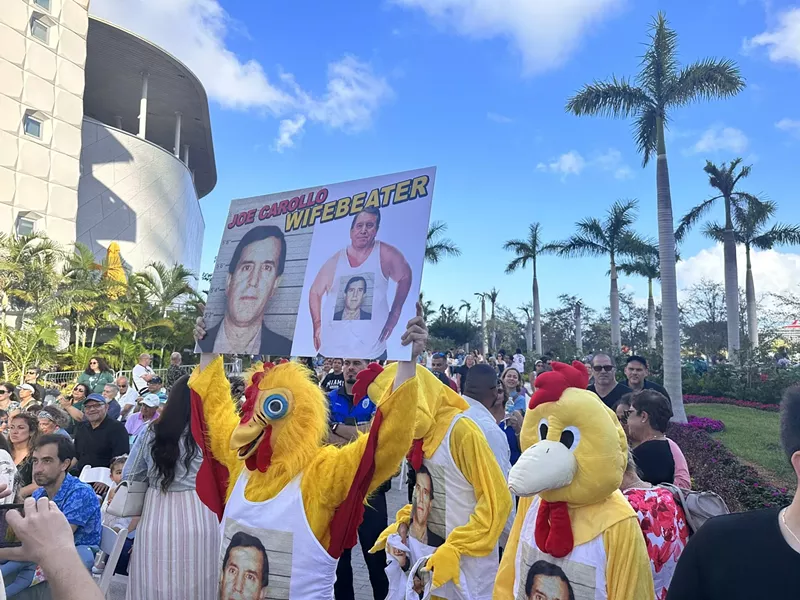 Image: Men dressed as chickens protest at Commissioner Joe Carollo's pet sculpture park grand opening on February 11, 2023.
