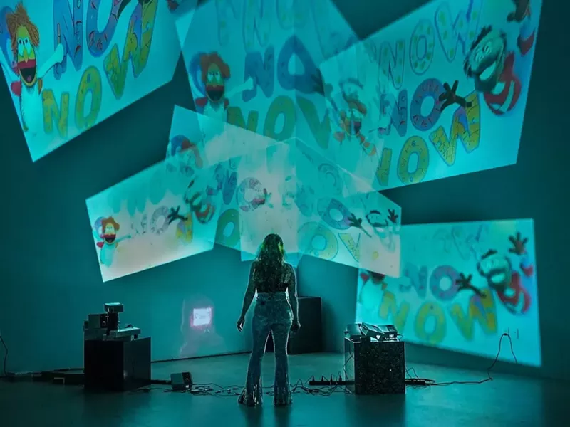 Image: Haiiileen standing in front of massive projections on the wall