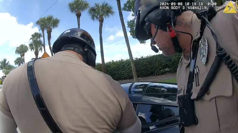 Miami-Dade police officer Danny Torres (right, with neck tattoos) has been placed on administrative leave following an incident during a traffic stop of Miami Dolphins wide receiver Tyreek Hill.