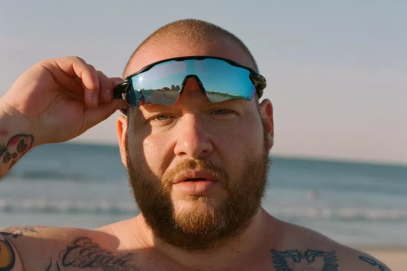 Image: Rapper Action Bronson lifting up his sunglasses