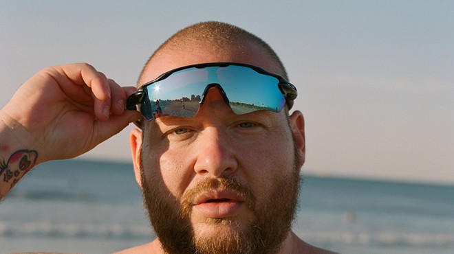 Rapper Action Bronson lifting up his sunglasses