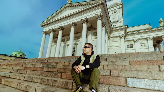 A man sitting on a stair in front of a church.