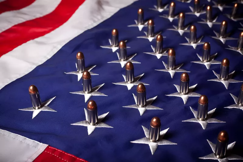 Image: An American flag with bullets placed on each star