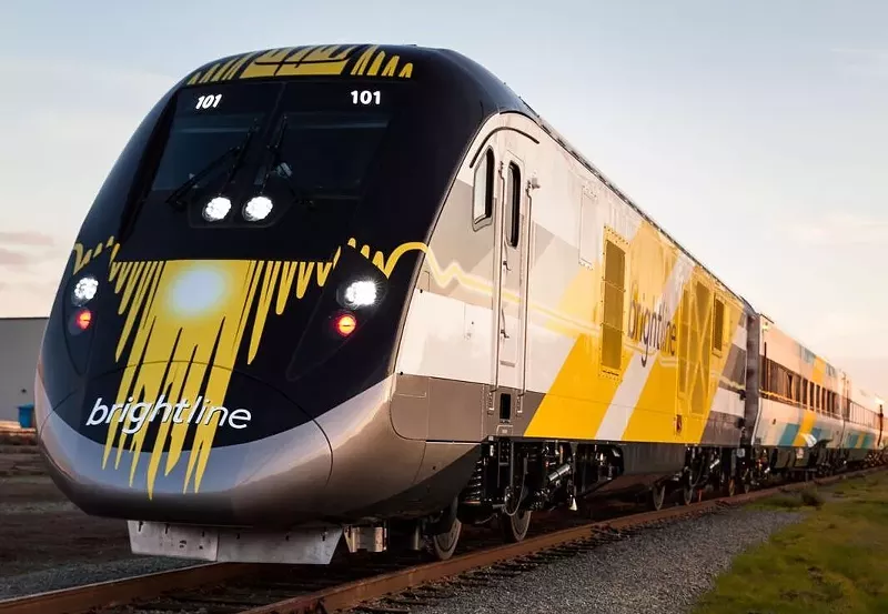 Image: A Brightline train sits on the tracks.