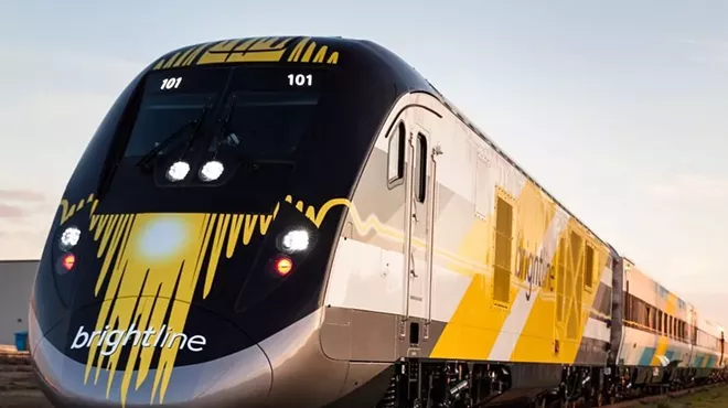 A Brightline train sits on the tracks.