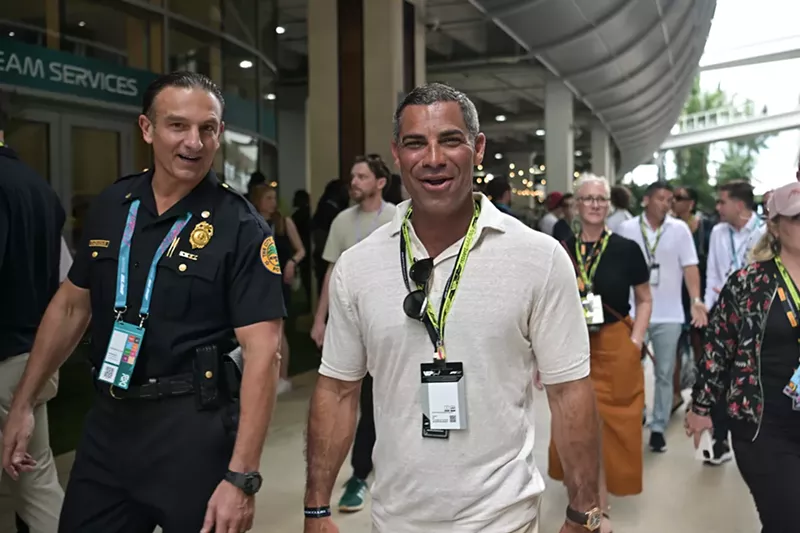 Image: Miami Mayor Francis Suarez walking in the paddock with a city of Miami police officer at the 2025 Miami Grand Prix.