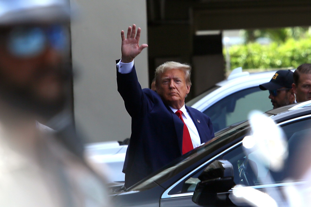Former president Donald Trump waves as he makes a visit to the Cuban restaurant Versailles after he appeared for his arraignment on June 13, 2023 in Miami, Florida.