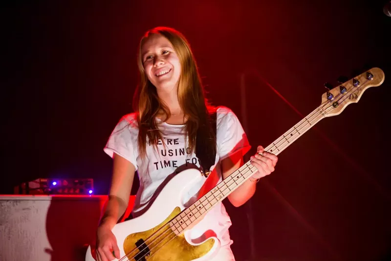 Image: karina rykman in a t-shirt holding a guitar