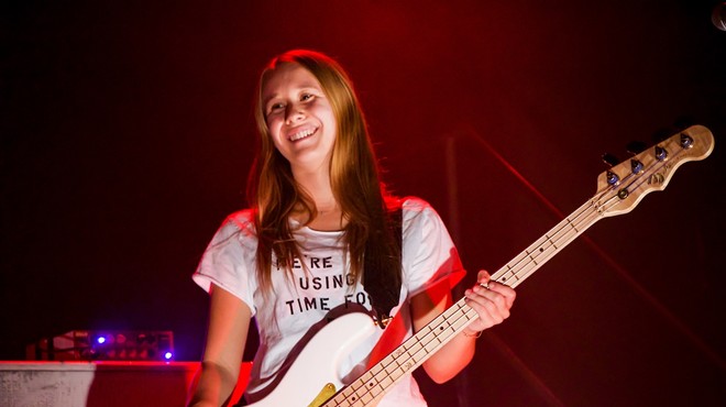karina rykman in a t-shirt holding a guitar