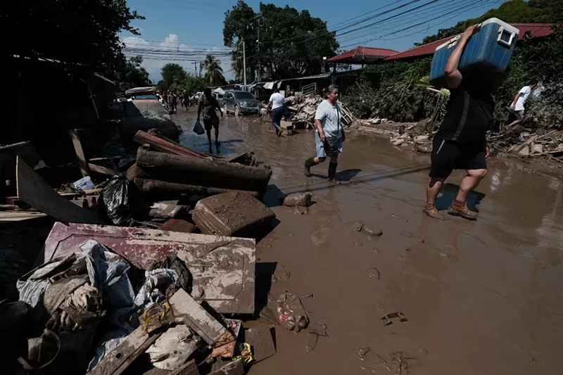 Image: Residents walk in the flooded streets of Colonia Planeta in La Lima, Honduras, in the aftermath of Eta.