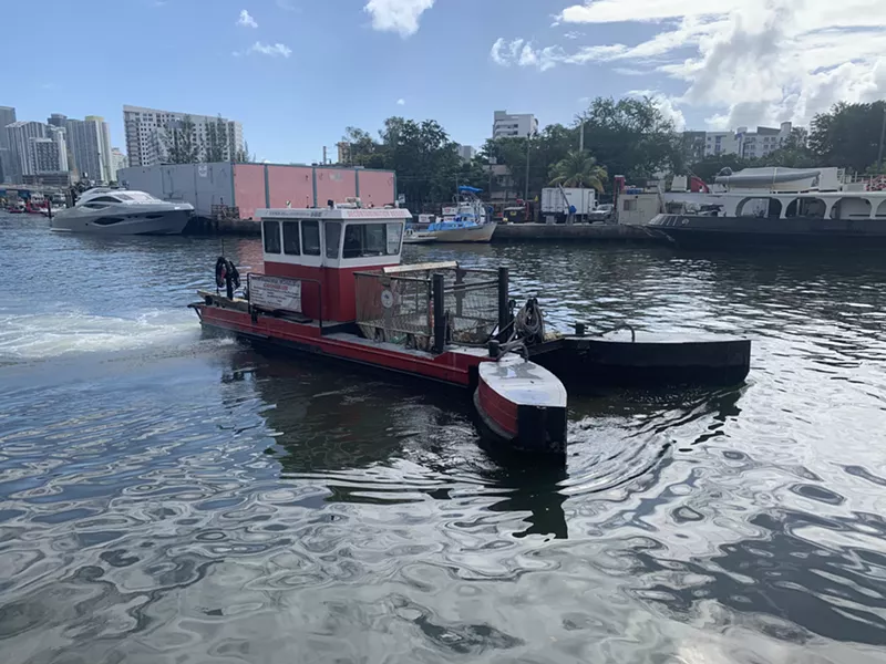 Image: A water decontamination vessel navigates the Miami River to remove trash and clean the waters thanks to Kiki on the River's sponsorship.