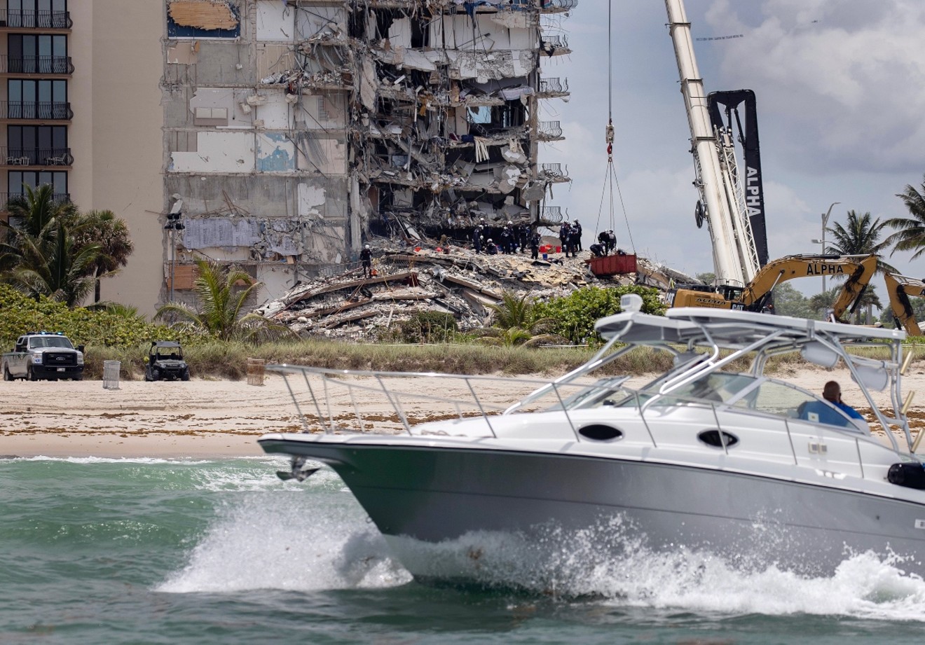 A boat passes off shore as members of the South Florida Urban Search and Rescue team look for possible survivors.
