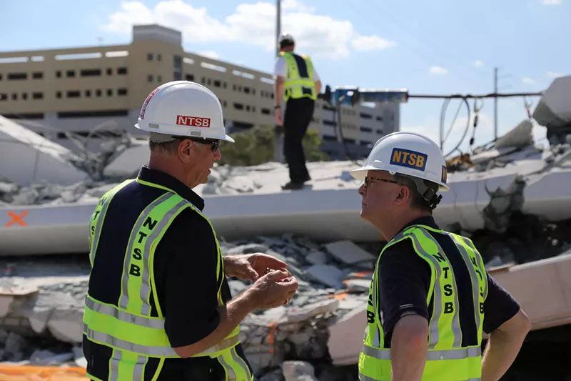 Image: A member of the National Transportation Safety Board investigates the collapse of a bridge on the FIU campus.