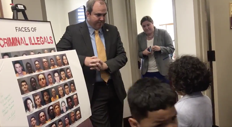 Image: State Sen. Joe Gruters stands next to an anti-immigrant sign like a proud parent.