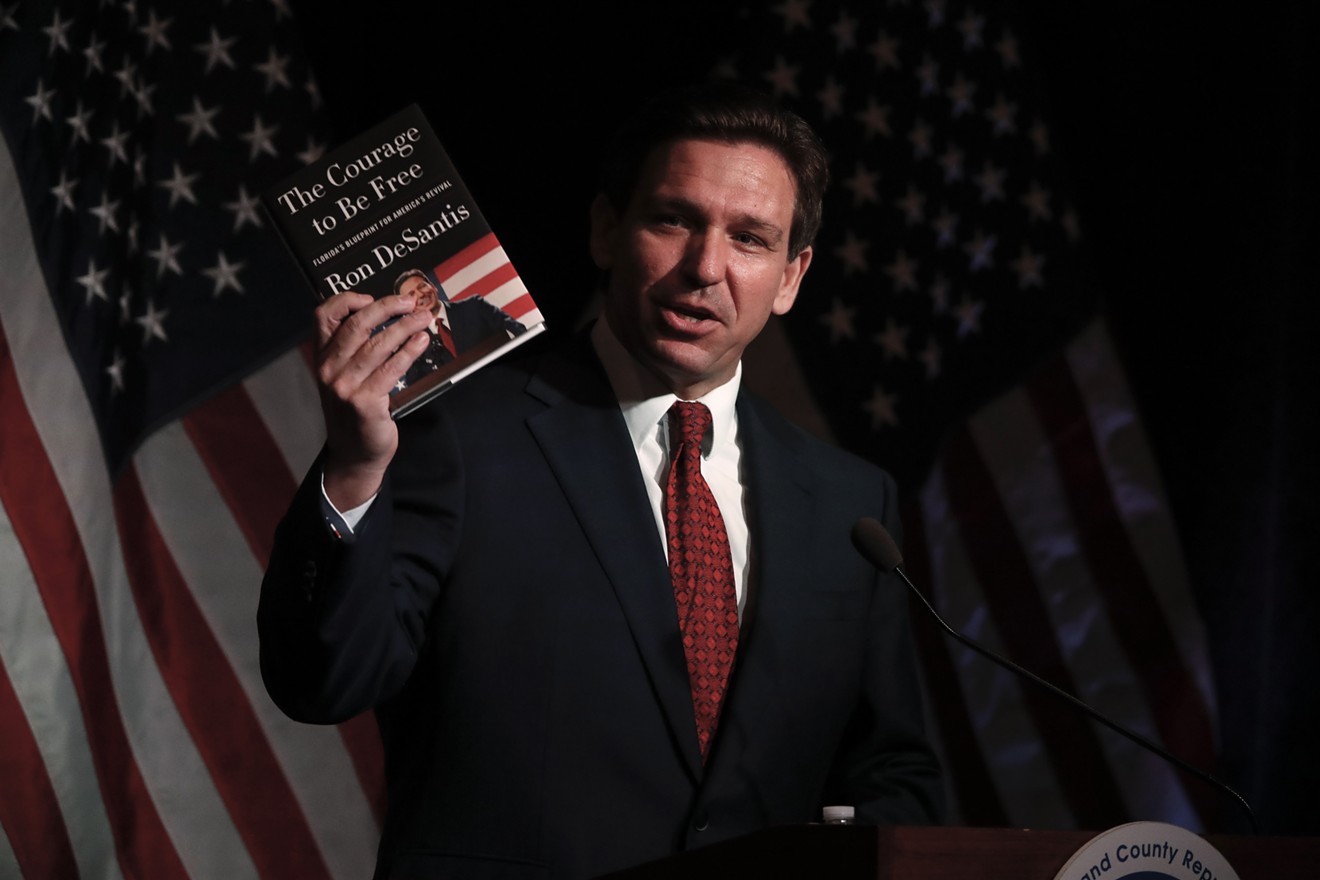 Florida Gov. Ron DeSantis holds his book while speaking at the Midland County Republican Party Dave Camp Spring Breakfast on April 6, 2023, in Michigan.