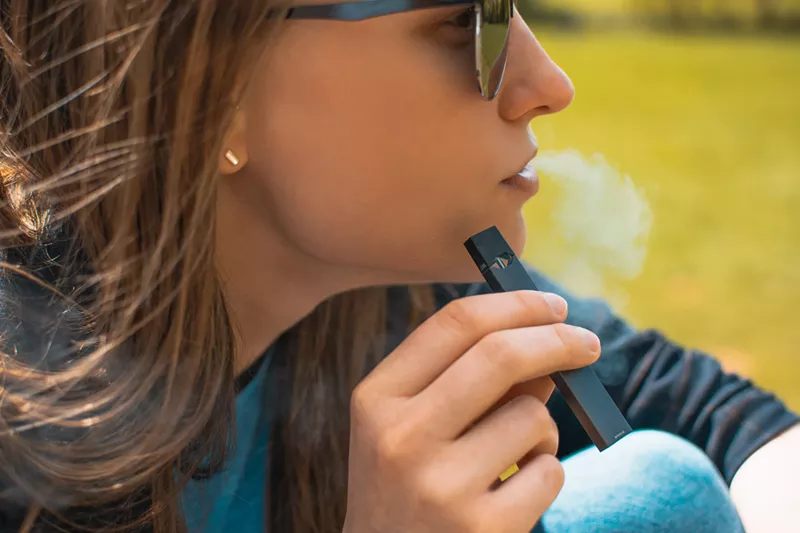Image: A young woman with a Juul.