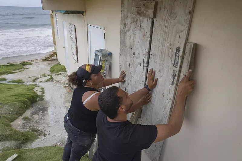 Image: Yamary Morales and Henry Sustache nail plywood over the windows of their home as they prepare for the arrival of Tropical Storm Dorian in Yabucoa, Puerto Rico.