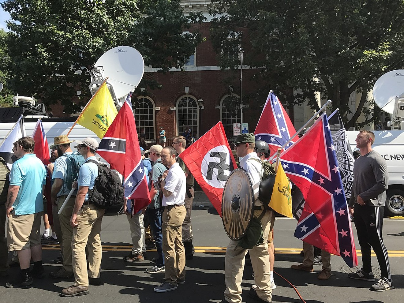 At the Unite the Right rally in Charlottesville August 12, 2017, alt-right members prepare to enter Emancipation Park holding Nazi, Confederate, and Gadsden "Don't Tread on Me" flags.