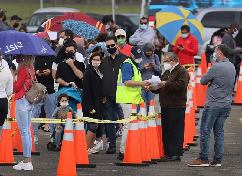 Image: People stand in line to receive a COVID-19 vaccine at the Miami Dade College North Campus on March 10.