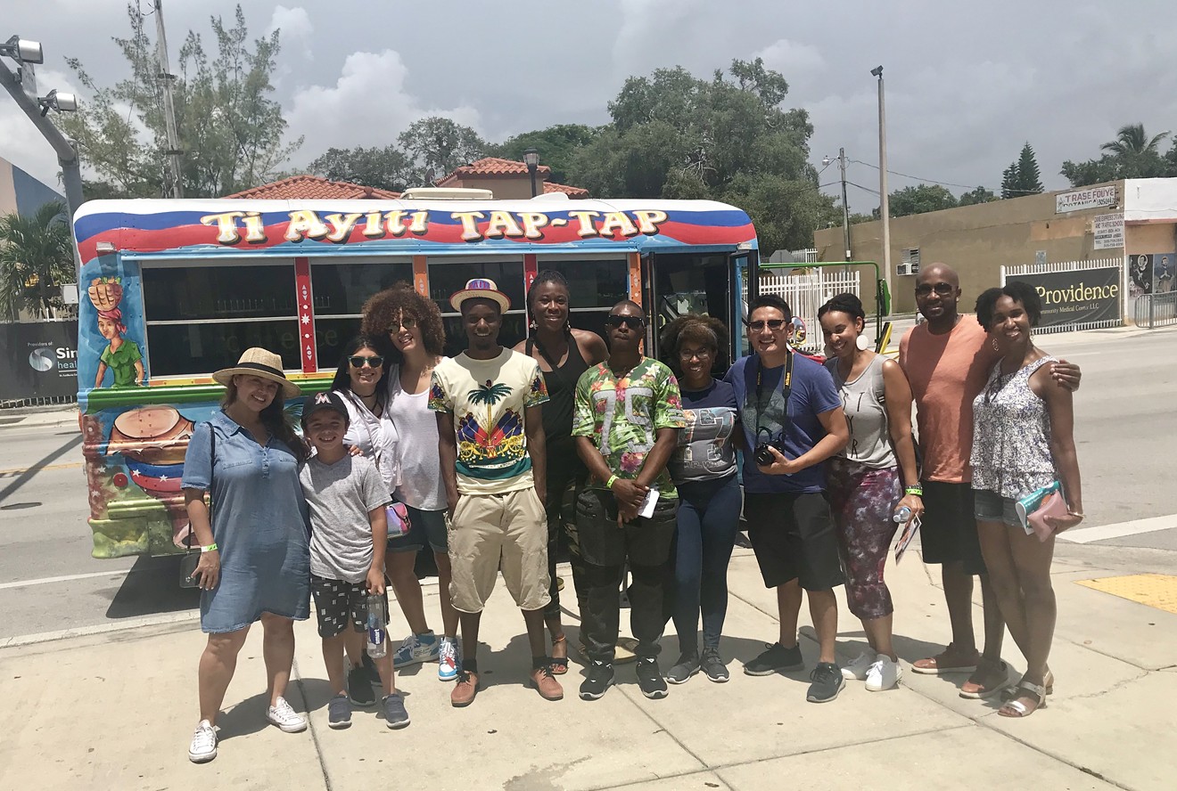 Riders gather for a photo with the Little Haiti tour bus.