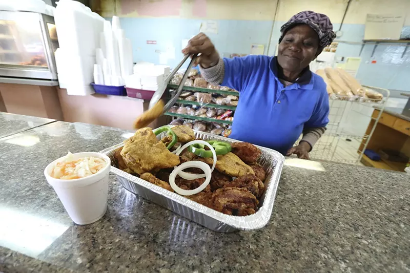 Image: Clemence Filiasse Alpazile prepares a platter of fried chicken.