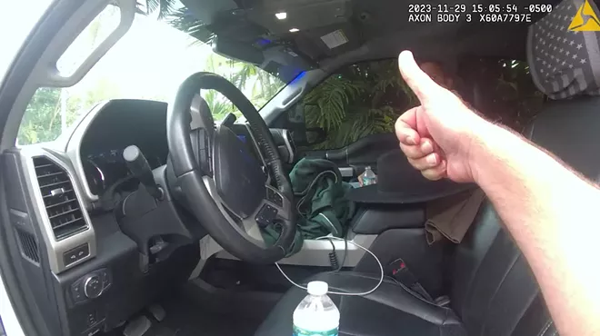 Miami-Dade Police officer gives a thumbs up to one of the officers as he sits in the truck.